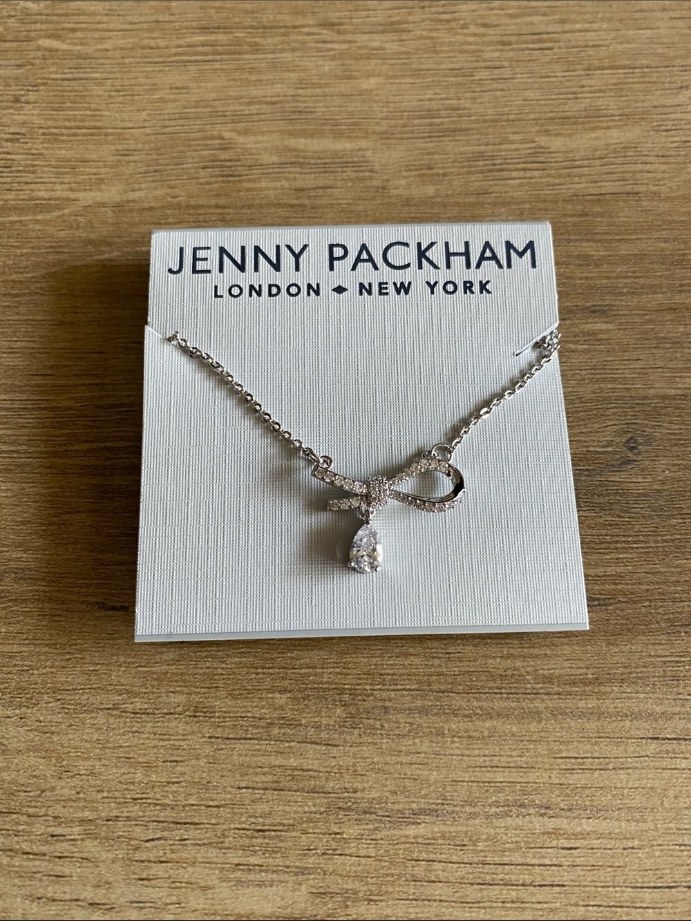 Jenny Packham silver colored half bow with tear drop necklace